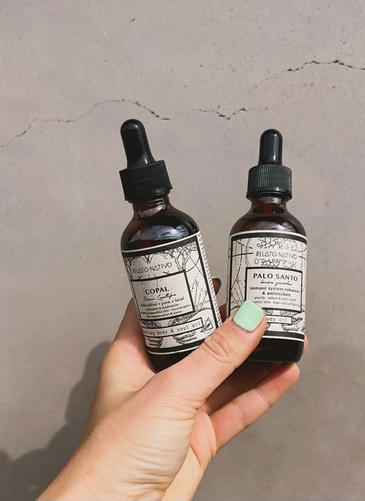 Palo Santo aromatherapy body oil, two bottles held by hand.